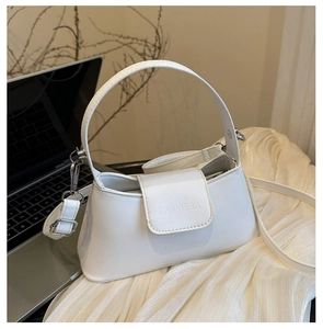 Close-up of white minimalist baguette bag with silver hardware and adjustable strap