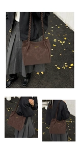 Detailed view of brown suede tote bag featuring unique braided rope shoulder straps