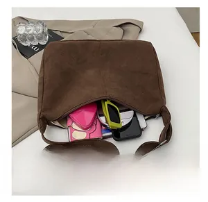 Top view of spacious brown suede tote bag interior with sunglasses and wallet