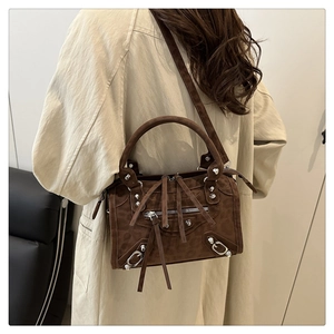 Detail of brown suede motorcycle bag with leopard pattern, silver studs and long tassels