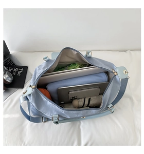 Detailed interior of light blue travel bag showing spacious storage for laptop and clothes