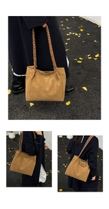 Detail of tan suede tote bag featuring distinctive double braided handles and logo print