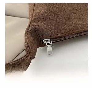Close-up of smooth silver metal zipper on a dark brown matte suede shoulder bag