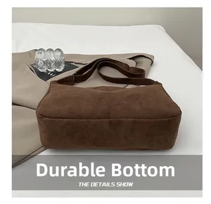 Detail view of the wide wear-resistant bottom on a vintage brown suede tote bag