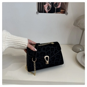 Close-up of leopard pattern velvet bag with gold chain and unique metallic buckle detail