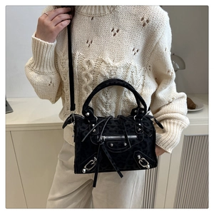 Close-up of black leopard print bag featuring silver studs and long fringe tassels