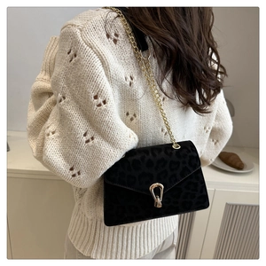 Detail of leopard print velvet crossbody bag with gold chain and horseshoe buckle