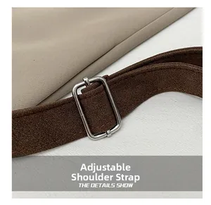 Close-up of adjustable brown nylon shoulder strap with silver metal buckle detail