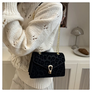 Detail of leopard print shoulder bag with gold chain strap and metallic U-shaped lock