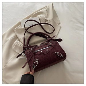 Detail of burgundy leopard print Boston bag with silver studs and long leather tassels