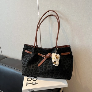 Vintage leopard print tote bag with brown leather handles and a plush charm on books