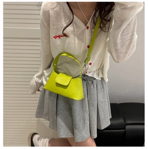 Detail of lime green mini crossbody bag with smooth faux leather and shoulder strap