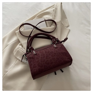 Close-up of burgundy leopard print Boston bag with metallic silver stud detailing