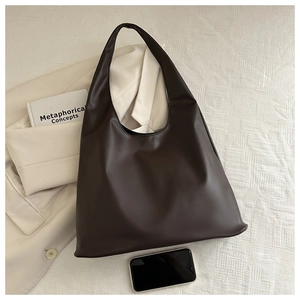 Detail of dark brown leather tote bag showing large capacity and smooth PU texture