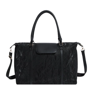 Large capacity black travel tote with unique pleated texture and adjustable crossbody strap