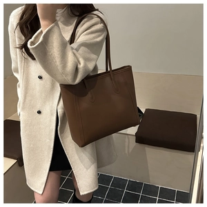 Detail of a large vintage brown tote bag showing smooth matte texture and minimalist style