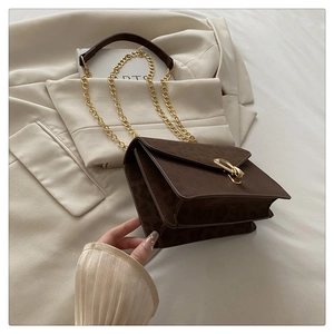 Detail of leopard print crossbody bag with gold metallic twist lock on beige fabric