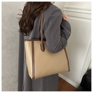 Detail of vintage tote bag showing contrasting brown edges and beige smooth texture