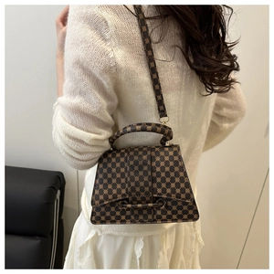 Detailed side view of vintage monogram crossbody bag with golden hardware on a model