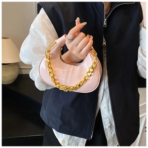 Pink glossy patent leather dumpling bag with chunky gold chain handle detail view
