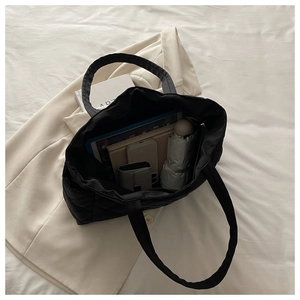 Detail showing high-capacity black quilted tote bag storage for tablets and books