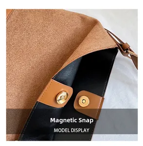 Detailed close-up of the magnetic buckle closure on a brown suede bucket bag