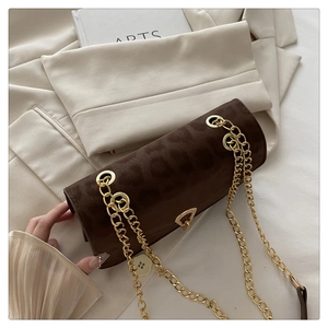 Detail of leopard print handbag with golden triangle lock and elegant chain strap