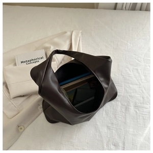 Macro shot of spacious dark brown faux leather tote bag with books showing large capacity