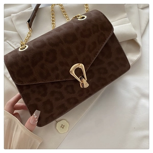 Detail of leopard print suede shoulder bag with gold chain strap and vintage metal clasp