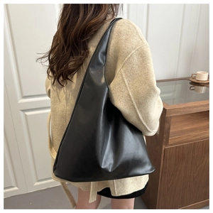 Detail of a black minimalist large hobo tote bag in soft matte leather texture