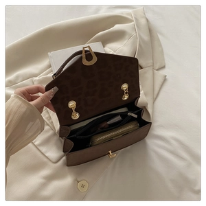 Detailed interior of leopard print handbag with zipper pocket and metal lock
