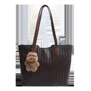 Deep brown woven tote bag with leather straps and a cute plush dog charm decoration