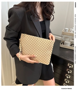 Detailed close-up of a fashionable envelope clutch with geometric circular patterns
