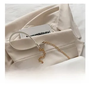 Detail of cream PU leather crossbody bag with gold M-letter clasp and chain strap