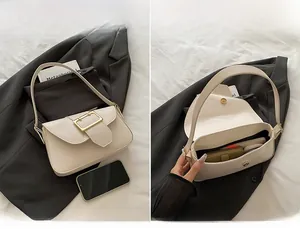 Vue divisée montrant la capacité intérieure et la boucle dorée du sac baguette beige