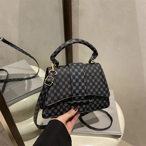 Elegant black and grey patterned crossbody bag with gold hardware and top handle