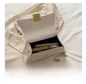 Internal storage view of white chain crossbody bag showing space for phone and wallet