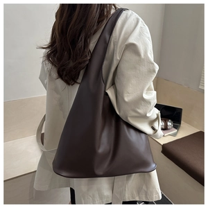 Detail view of large dark brown leather tote bag showing hobo style shoulder fit