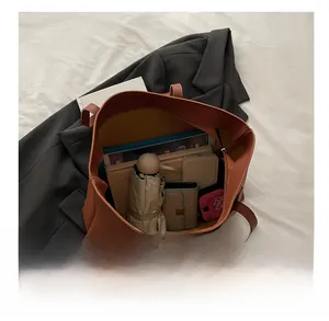 Vue intérieure du sac cabas marron montrant sa grande capacité pour laptop et objets