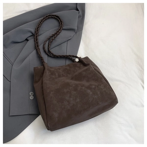 Detail of dark brown tote bag with woven straps on a grey suit for a professional look