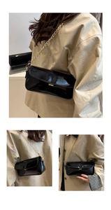 Détail du sac à bandoulière en cuir verni noir avec chaîne dorée et fermoir en métal