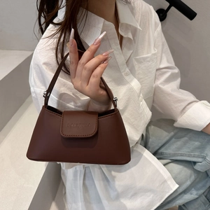 Brown trapezoid faux leather baguette bag with top handle and embossed logo detail