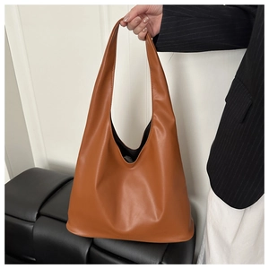 Close-up of caramel minimalist tote bag with integrated handle showing smooth leather texture