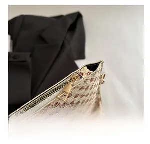 Detail of smooth gold metal zipper on a retro geometric pattern clutch bag