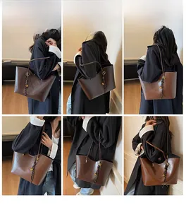 Brown leather tote bag featuring a decorative woven tassel and metallic gold orb detail