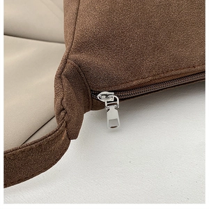 Detailed close-up of brown suede tote bag showing metal zipper and fine stitching