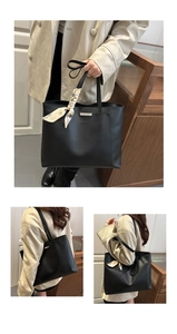 Close-up of black leather tote bag with silver bar detail and silk scarf decoration