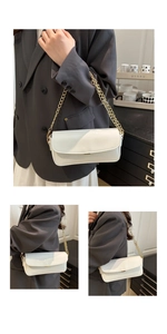 Détail du sac blanc en cuir verni avec chaîne dorée sur une veste de costume grise