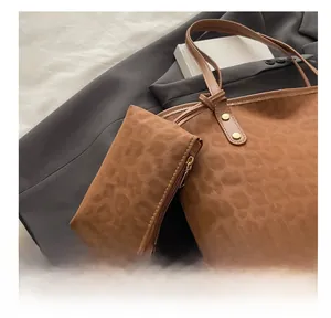 Detail of leopard print tote bag with matching zippered pouch on grey blazer fabric