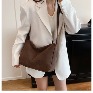 Grande borsa hobo marrone in pelle scamosciata retrò abbinata a blazer bianco